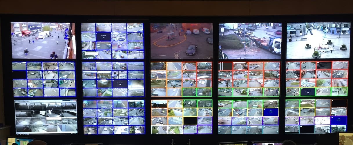 Sala de controle com parede de monitores de videomonitoramento